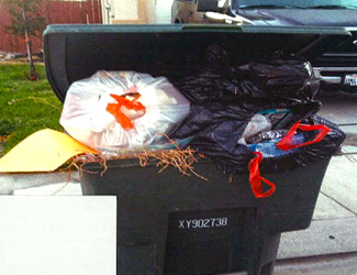 Green waste cart filled with plastic bags
