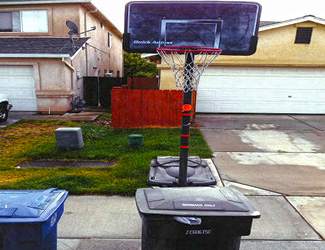Waste bin placed underneath basketball hoop